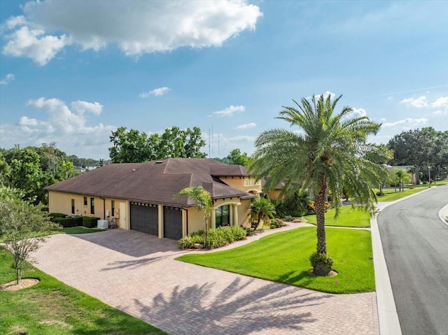 6357 Ashley Dr, Lakeland, FL 33813 - view of front of house featuring an attached garage, decorative driveway, a front yard, and stucco siding