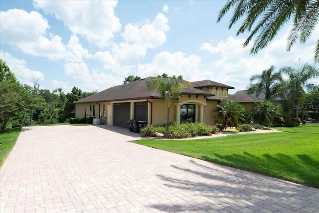 6357 Ashley Dr, Lakeland, FL 33813 - mediterranean / spanish-style house with an attached garage, stucco siding, a front lawn, and decorative driveway