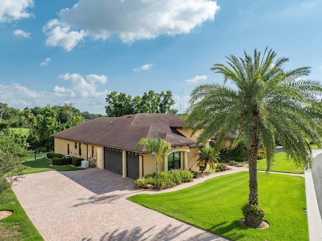 6357 Ashley Dr, Lakeland, FL 33813 - view of front of home with an attached garage, stucco siding, decorative driveway, a front yard, and a shingled roof