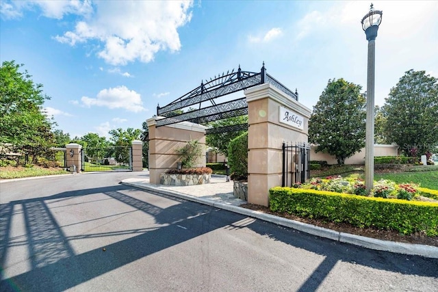 6357 Ashley Dr, Lakeland, FL 33813 - view of asphalt road with a gate, curbs, street lighting, and a gated entry