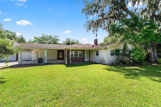 5425 Lewellyn Rd, Lakeland, FL 33810 - back of house with an attached garage, central AC, a lawn, and a chimney