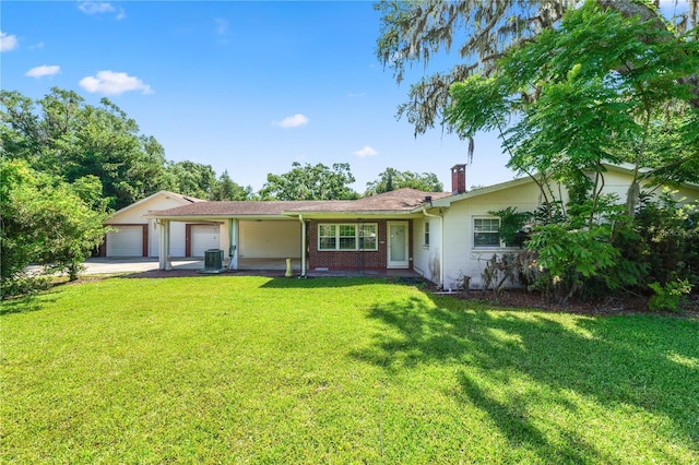 5425 Lewellyn Rd, Lakeland, FL 33810 - view of front of home with a chimney, a front yard, driveway, and a garage