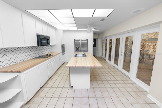 5425 Lewellyn Rd, Lakeland, FL 33810 - kitchen with butcher block counters, black appliances, a ceiling fan, tasteful backsplash, and white cabinets