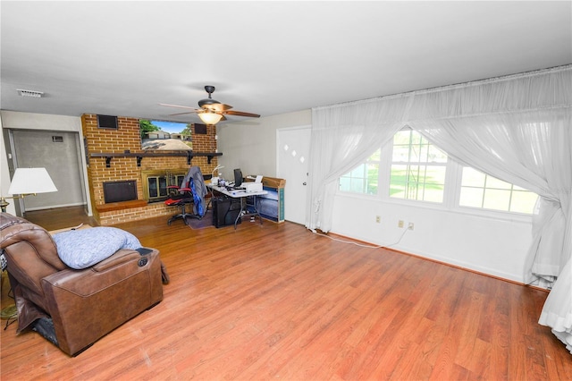 5425 Lewellyn Rd, Lakeland, FL 33810 - living room featuring a ceiling fan, wood finished floors, a brick fireplace, and baseboards