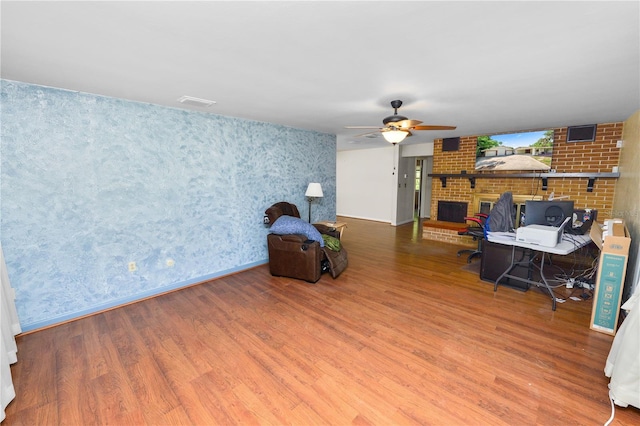 5425 Lewellyn Rd, Lakeland, FL 33810 - office featuring a fireplace, wood finished floors, wallpapered walls, a ceiling fan, and baseboards