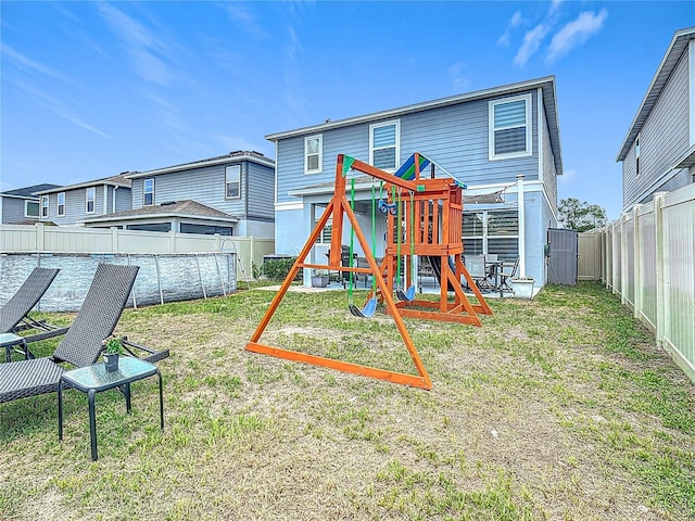 back of property featuring a playground