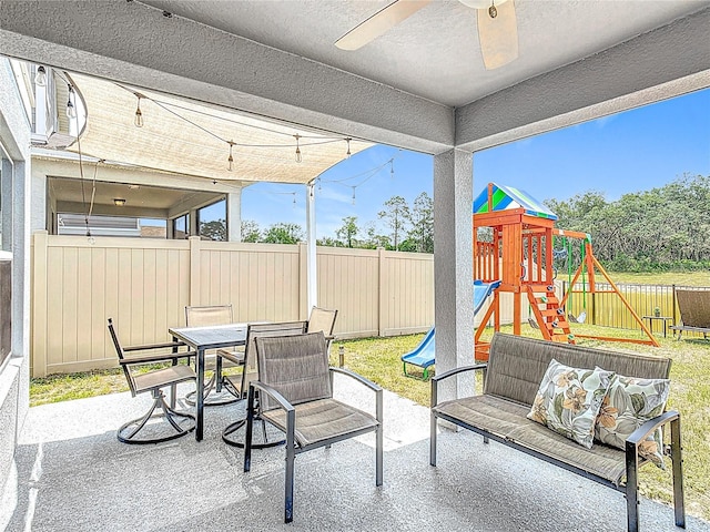 fenced backyard with a patio area, a playground, a ceiling fan, and outdoor dining area