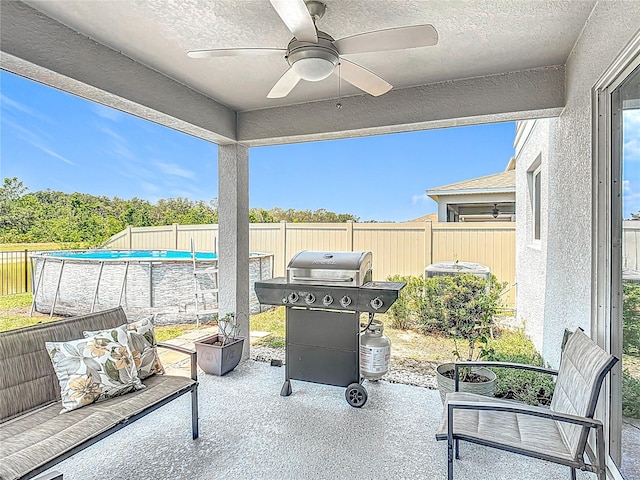 fenced backyard with a grill, a patio area, and a ceiling fan