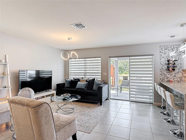 living area with tile patterned flooring and a textured ceiling