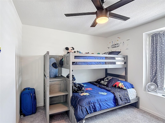 bedroom with carpet, a textured ceiling, ceiling fan, and baseboards