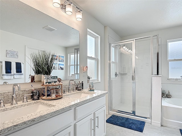 bathroom featuring a textured ceiling, a shower stall, a bath, tile patterned flooring, and double vanity