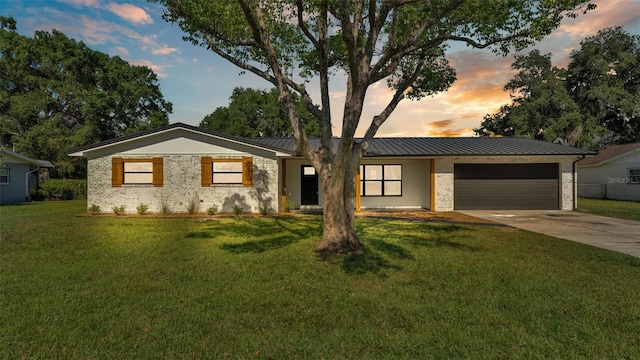 6543 Tula Ln, Lakeland, FL 33809 - view of front of property featuring an attached garage, concrete driveway, a front lawn, a standing seam roof, and brick siding