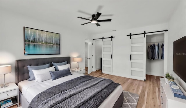 6543 Tula Ln, Lakeland, FL 33809 - bedroom featuring a barn door, light wood-style flooring, a closet, and ceiling fan