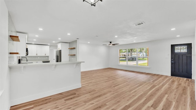 6543 Tula Ln, Lakeland, FL 33809 - unfurnished living room with recessed lighting, light wood finished floors, baseboards, ceiling fan, and a sink