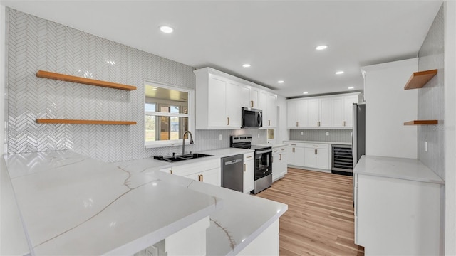 6543 Tula Ln, Lakeland, FL 33809 - kitchen with open shelves, wine cooler, appliances with stainless steel finishes, a sink, and white cabinetry