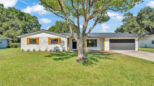 6543 Tula Ln, Lakeland, FL 33809 - view of front of home with a garage, concrete driveway, a standing seam roof, a front yard, and metal roof