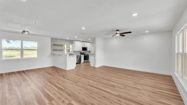 6543 Tula Ln, Lakeland, FL 33809 - unfurnished living room featuring light wood-style flooring, baseboards, recessed lighting, a sink, and ceiling fan