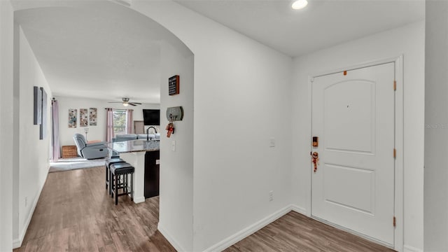 2293 Caspian Dr, Lakeland, FL 33805 - entrance foyer featuring wood finished floors, arched walkways, a ceiling fan, and baseboards