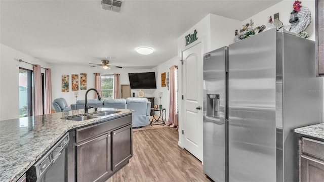 2293 Caspian Dr, Lakeland, FL 33805 - kitchen with stainless steel refrigerator with ice dispenser, a sink, light wood-style floors, light stone counters, and a ceiling fan