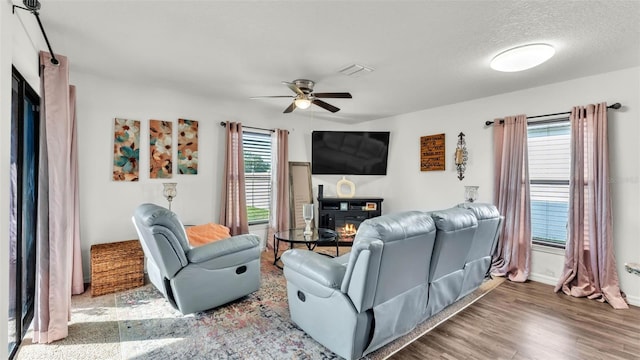 2293 Caspian Dr, Lakeland, FL 33805 - living area with a ceiling fan, wood finished floors, a glass covered fireplace, and baseboards