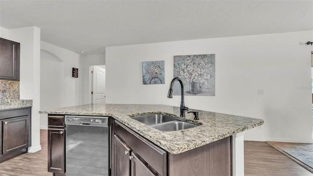 2293 Caspian Dr, Lakeland, FL 33805 - kitchen featuring stainless steel dishwasher, a sink, light wood-type flooring, baseboards, and dark brown cabinets
