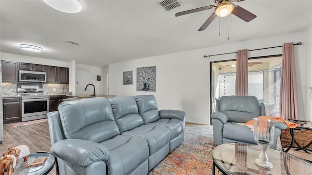 2293 Caspian Dr, Lakeland, FL 33805 - living area featuring ceiling fan, a textured ceiling, and light wood-type flooring