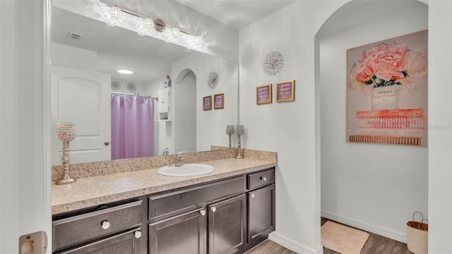 2293 Caspian Dr, Lakeland, FL 33805 - bathroom with vanity, wood finished floors, baseboards, and a shower with shower curtain