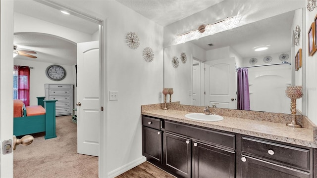 2293 Caspian Dr, Lakeland, FL 33805 - bathroom with ceiling fan, vanity, a shower with curtain, a textured ceiling, and baseboards