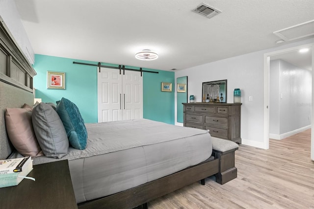3810 Harrelson Rd, Lakeland, FL 33810 - bedroom with a barn door, light wood-type flooring, and baseboards