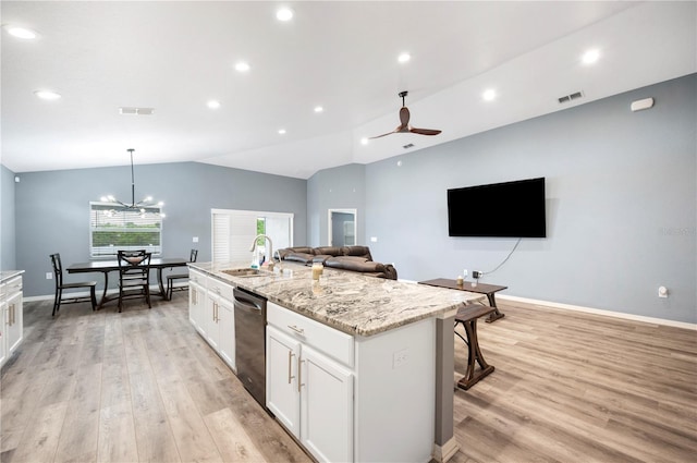 3883 Sandhill Crane Dr, Lakeland, FL 33811 - kitchen with stainless steel dishwasher, a sink, vaulted ceiling, light wood finished floors, and a kitchen island with sink