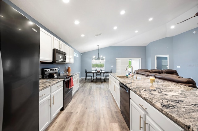 3883 Sandhill Crane Dr, Lakeland, FL 33811 - kitchen with black appliances, a sink, lofted ceiling, white cabinets, and light wood-type flooring