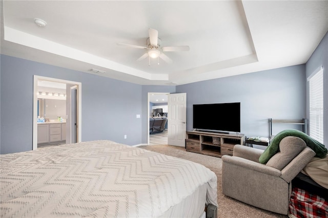 3883 Sandhill Crane Dr, Lakeland, FL 33811 - bedroom featuring a raised ceiling, ceiling fan, connected bathroom, and light colored carpet