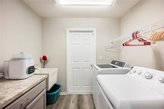3883 Sandhill Crane Dr, Lakeland, FL 33811 - laundry room featuring washing machine and dryer, light wood-type flooring, and cabinet space