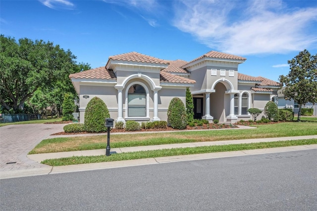 6527 Eagle Ridge Way, Lakeland, FL 33813 - mediterranean / spanish-style home with a tile roof, decorative driveway, stucco siding, and a front lawn