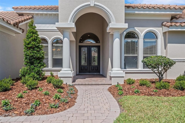 6527 Eagle Ridge Way, Lakeland, FL 33813 - property entrance with french doors, stucco siding, and a tiled roof