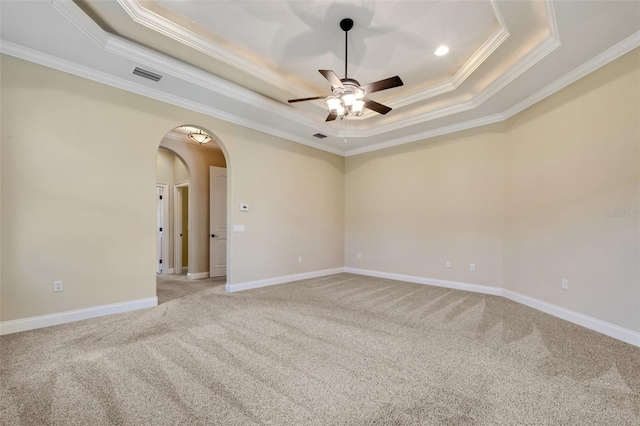 6527 Eagle Ridge Way, Lakeland, FL 33813 - empty room with a tray ceiling, crown molding, a ceiling fan, light colored carpet, and arched walkways
