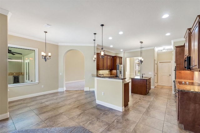 6527 Eagle Ridge Way, Lakeland, FL 33813 - kitchen with stainless steel appliances, a center island, arched walkways, dark stone counters, and ornamental molding