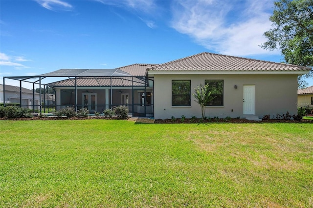 6527 Eagle Ridge Way, Lakeland, FL 33813 - rear view of property featuring ceiling fan, a lawn, a tile roof, stucco siding, and glass enclosure