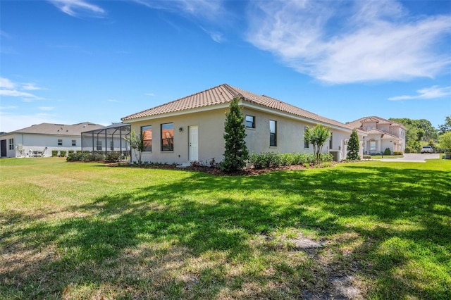 6527 Eagle Ridge Way, Lakeland, FL 33813 - view of side of property with a tile roof, a yard, stucco siding, and glass enclosure