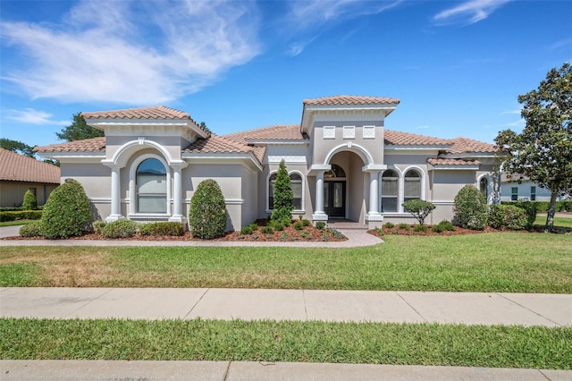 6527 Eagle Ridge Way, Lakeland, FL 33813 - mediterranean / spanish house featuring stucco siding, a front lawn, and a tiled roof