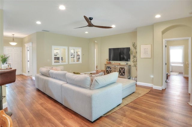 1233 Emerald Hill Way, Valrico, FL 33594 - living room with light wood-style floors, arched walkways, baseboards, a ceiling fan, and recessed lighting