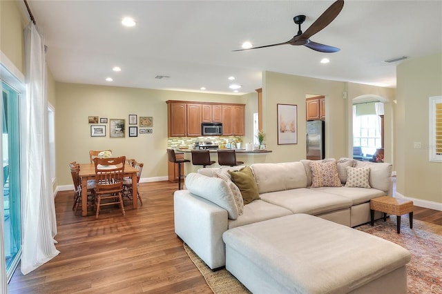 1233 Emerald Hill Way, Valrico, FL 33594 - living room featuring arched walkways, a ceiling fan, light wood-type flooring, recessed lighting, and baseboards