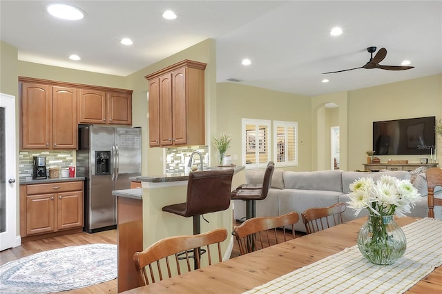 1233 Emerald Hill Way, Valrico, FL 33594 - kitchen featuring stainless steel refrigerator with ice dispenser, open floor plan, arched walkways, backsplash, and recessed lighting