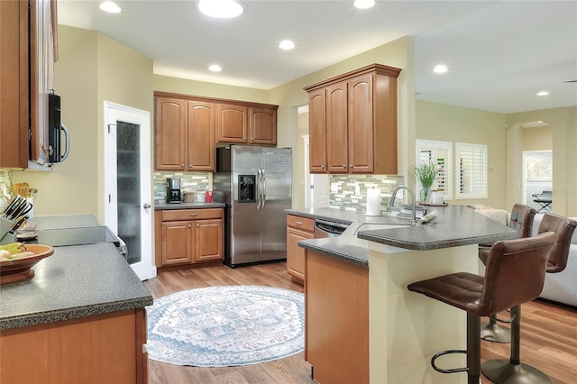 1233 Emerald Hill Way, Valrico, FL 33594 - kitchen featuring stainless steel appliances, a kitchen breakfast bar, a peninsula, a sink, and tasteful backsplash