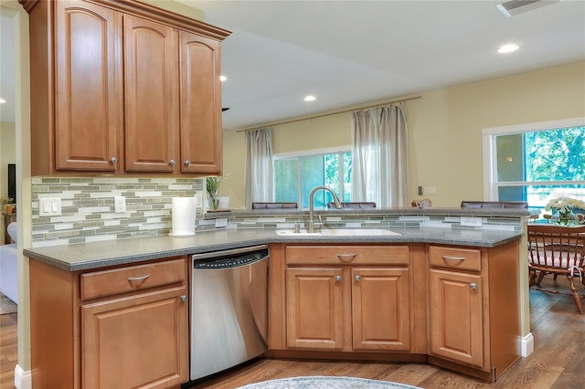 1233 Emerald Hill Way, Valrico, FL 33594 - kitchen with stainless steel dishwasher, a sink, light wood finished floors, a peninsula, and tasteful backsplash