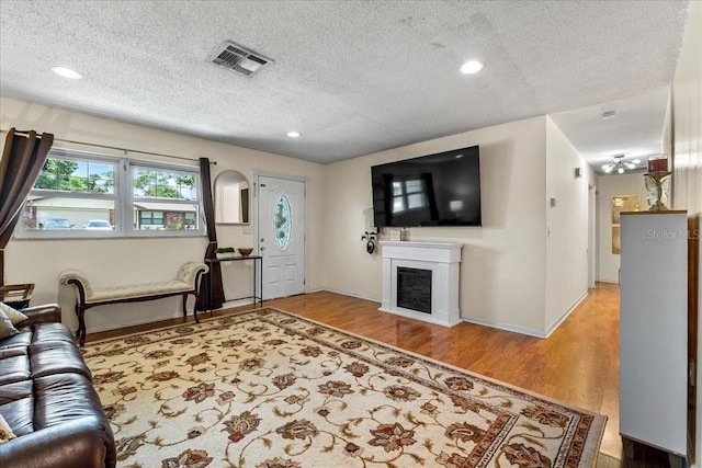 2810 Gary Ln, Lakeland, FL 33812 - living room featuring a textured ceiling, a fireplace, wood finished floors, baseboards, and recessed lighting