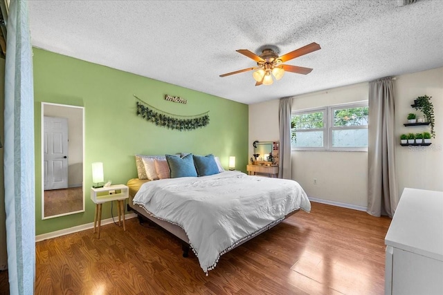 2810 Gary Ln, Lakeland, FL 33812 - bedroom featuring wood finished floors, a textured ceiling, baseboards, and a ceiling fan