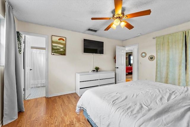 2810 Gary Ln, Lakeland, FL 33812 - bedroom with light wood finished floors, a textured ceiling, baseboards, and ceiling fan
