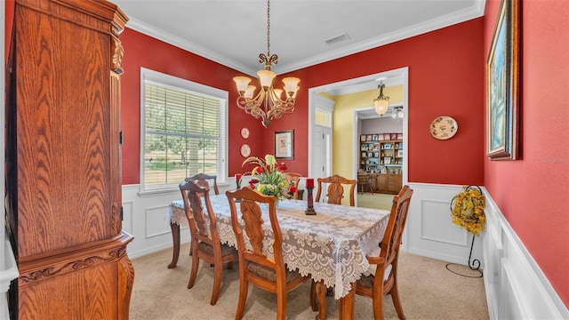 2025 Viewpoint Landings Rd, Lakeland, FL 33810 - dining room featuring a chandelier, light colored carpet, a wainscoted wall, ornamental molding, and a decorative wall