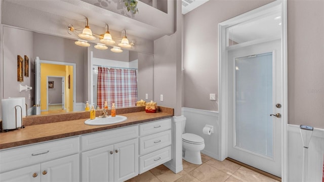 2025 Viewpoint Landings Rd, Lakeland, FL 33810 - full bath with toilet, vanity, tile patterned flooring, and wainscoting